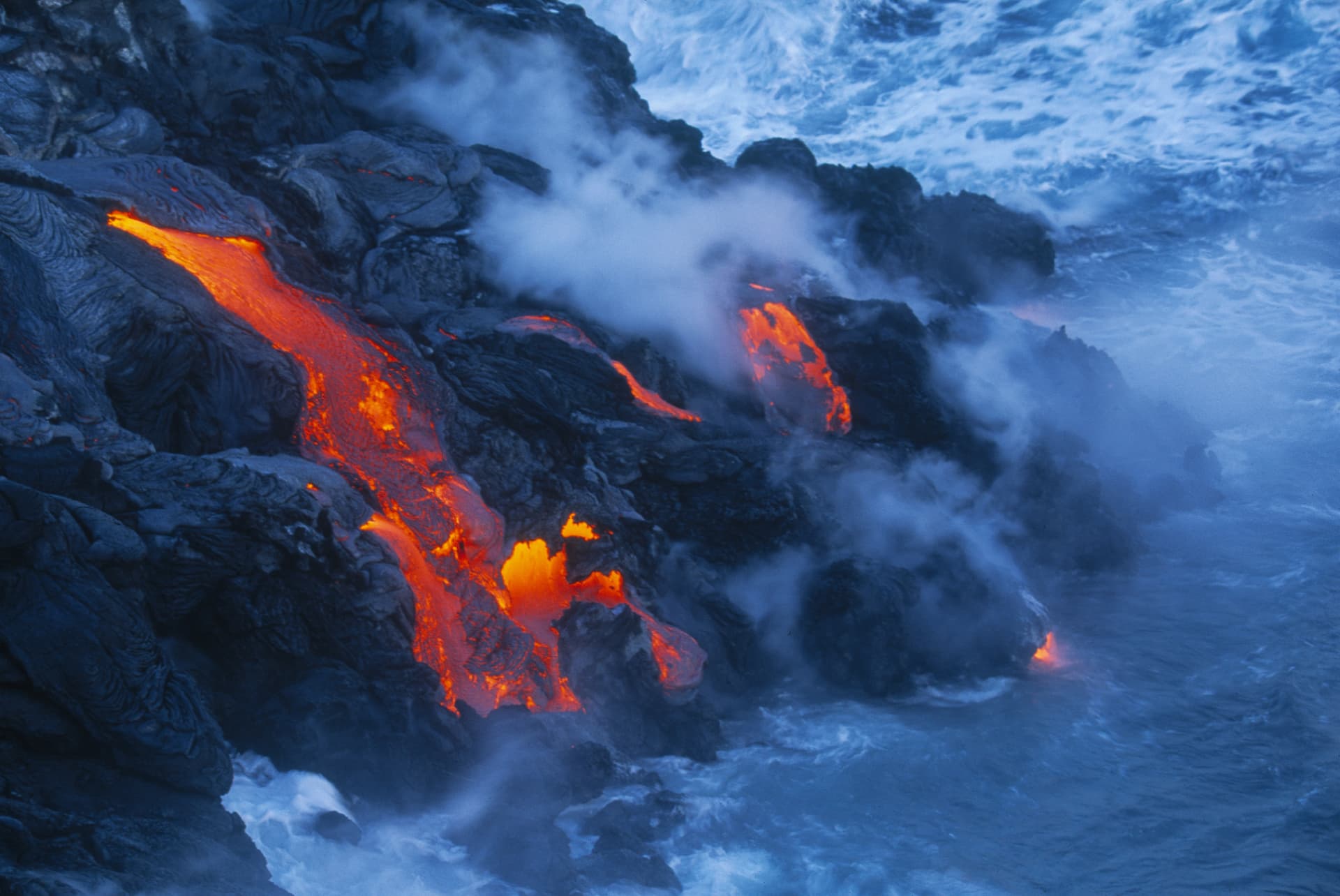 Molten lava meeting the sea, steam rising where fire meets water